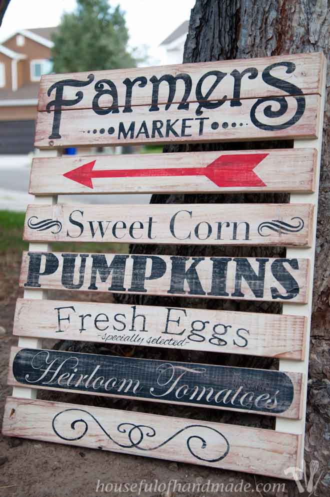 Farmers market wooden sign on side of road.