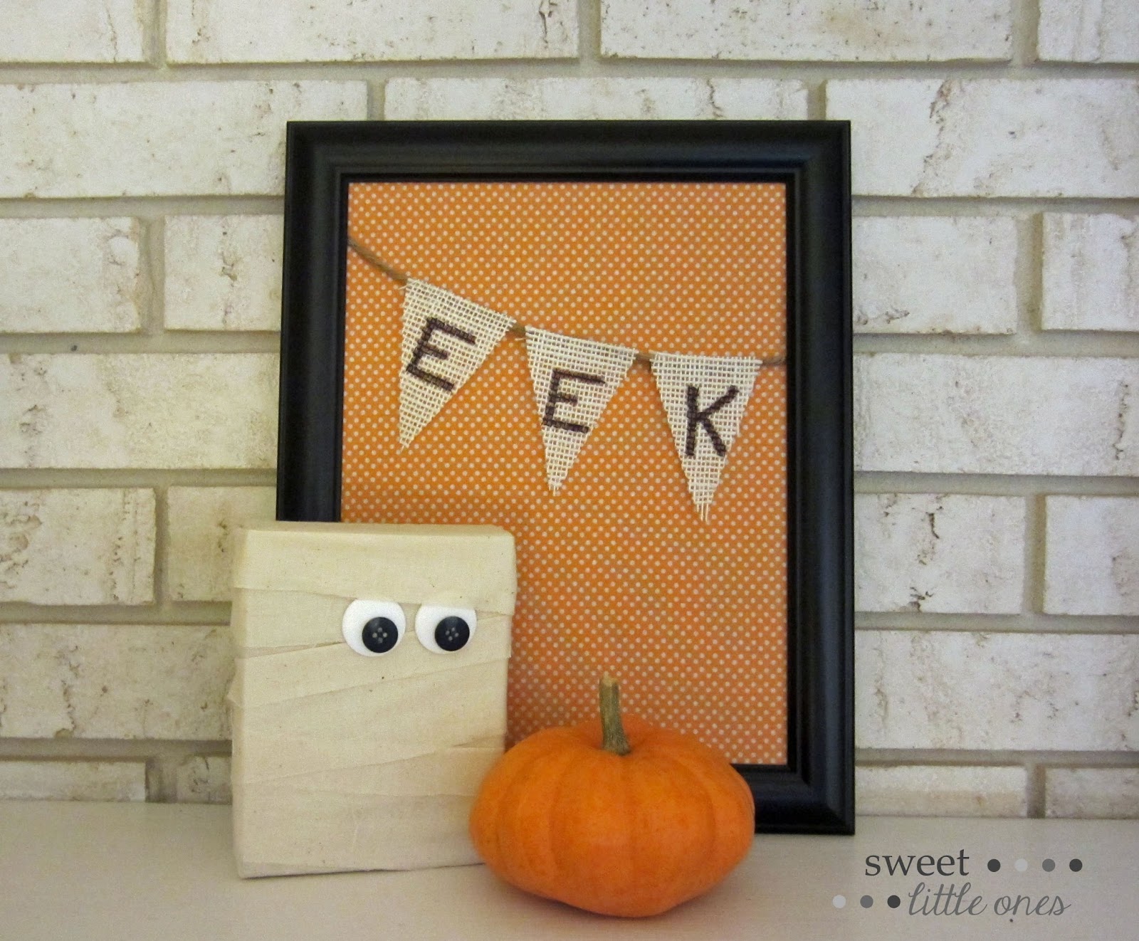 Eek sign and a mummy with eyes and a pumpkin o a mantel.