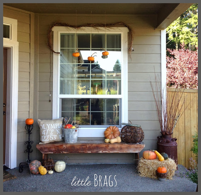 Lots of orange and white pumpkins and gourds on a front porch.