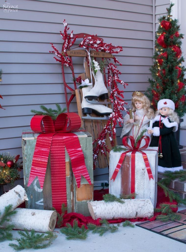 Outdoor scene of wrapped presents, figurines, and skates.